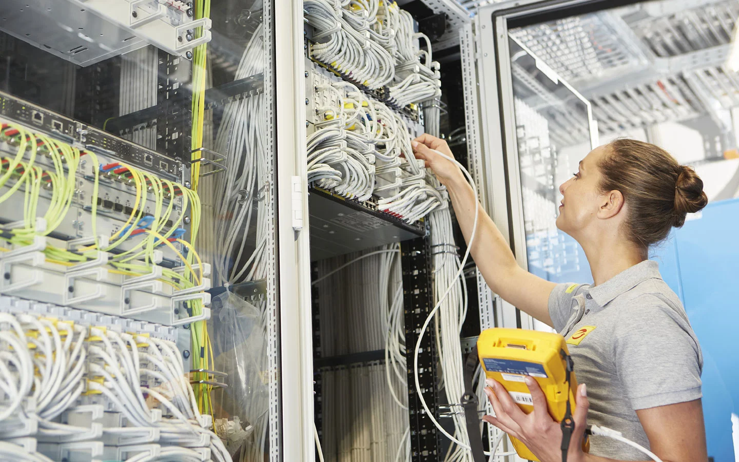 E-CHECK IT - Mitarbeiterin überprüft die Server-Installation mit einem Meßgerät · Elektro Busch GmbH