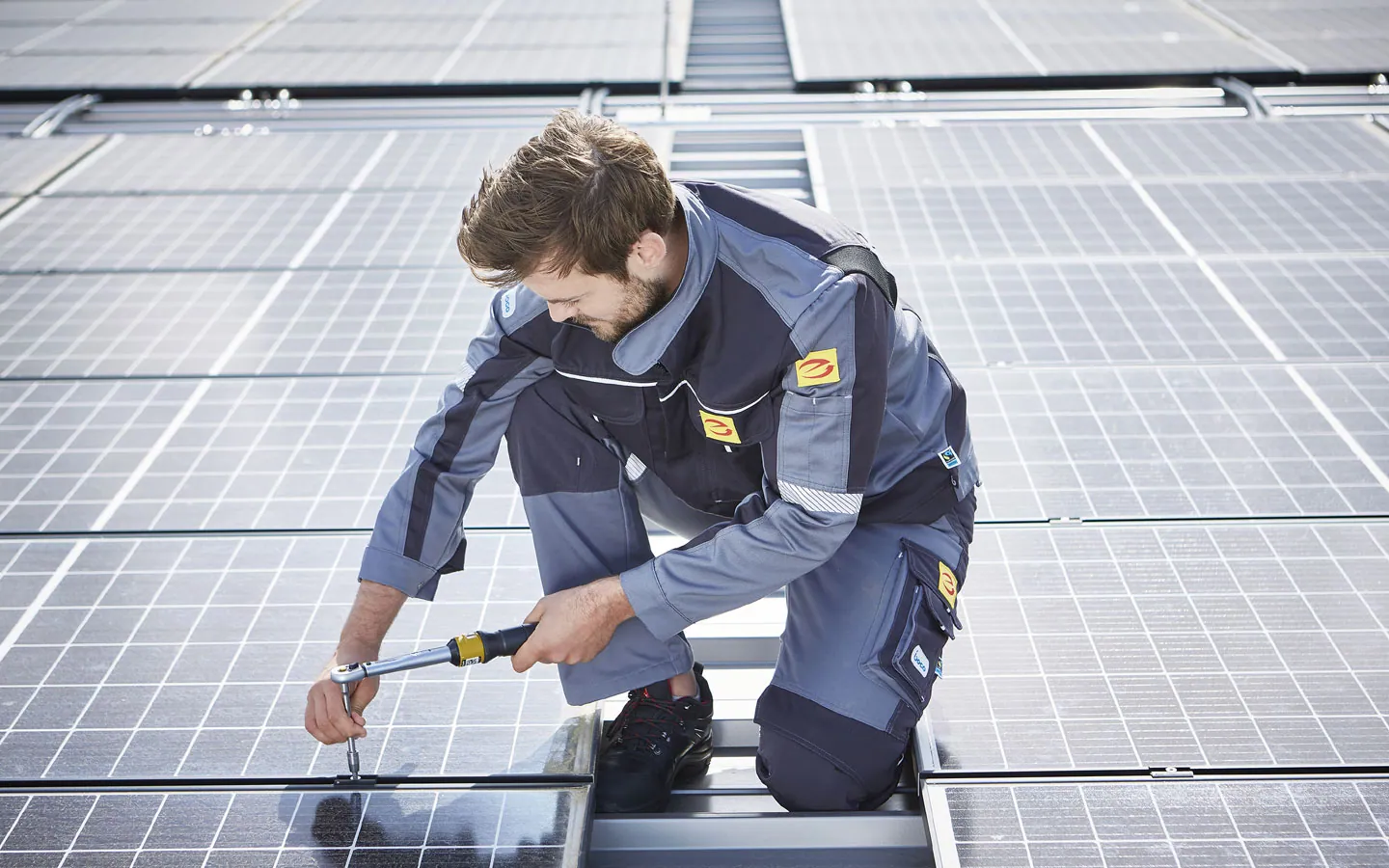 E-CHECK E-Mobilität - Mitarbeiter montiert auf dem Dach die neuen Solarmodule · Elektro Busch GmbH