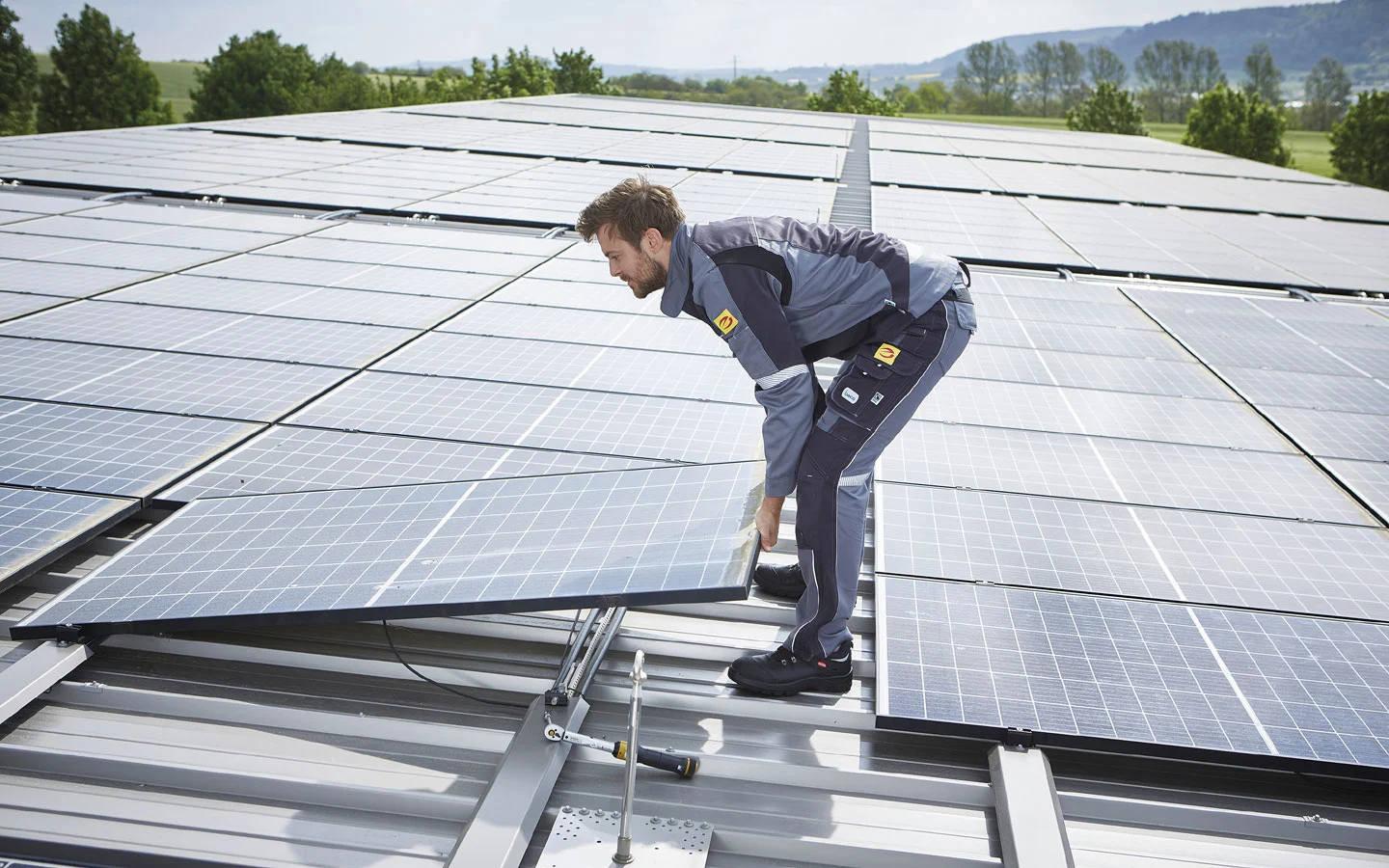 E-CHECK PV - Mitarbeiter installiert Solarzellen auf dem Dach · Elektro Busch GmbH