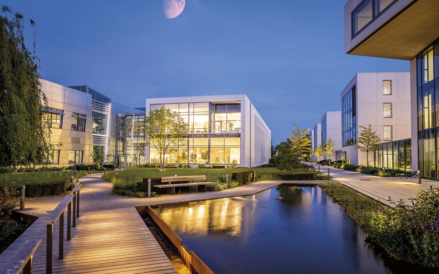 E-CHECK - Blick auf einige beleuchtete Gebäude am Abend · Elektro Busch GmbH