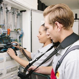 E-CHECK | Mitarbeiter prüfen die Sicherungsautomaten im Schaltschrank